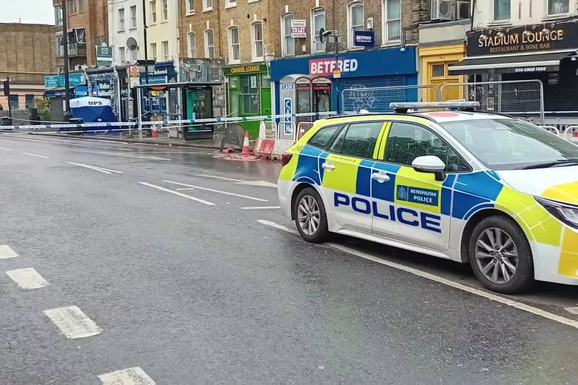 A shot of the Tottenham crime scene with a police car guarding the blue cordon