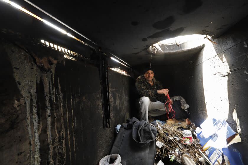 WATTS, CA - JUNE 14, 2022 - - Juan Luis Gonzalez-Castillo, 37, shows where he lived below a manhole in a vacant field in Watts on June 14, 2022. Gonzalez lived here since February of this year, but was forced from the place by an accidental fire that charred the walls inside the storm drain. "One day I walked in to this property and found a drain," he said. "I opened it, and it was dry. I cleaned a spider web. So I started living here," said Gonzalez-Castillo. The City of Los Angeles bought the 10-acre parcel in Watts with a plan to bring clean industries and jobs to Watts as part of the recovery from the L.A. Riots. Twenty-eight years later, the property is still vacant, covered in weeds and is used as a shooting range, a dumping ground for chopped cars and a home for homeless people who build shanties along the periphery of the lot. City Controller Ron Galperin wants it to be developed for homeless housing, but city officials persist in wanting industries. (Genaro Molina / Los Angeles Times)