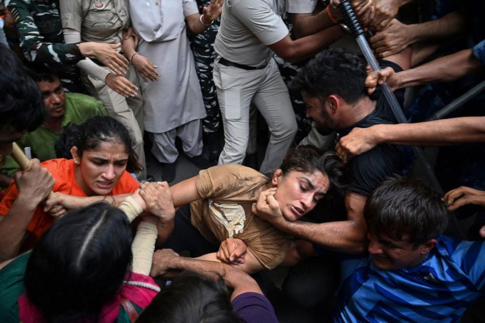 Indian wrestlers Sangeeta Phogat (L), and Vinesh Phogat (C) are detained by the police while attempting to march to India's new parliament, just as it was being inaugurated by Prime Minister Narendra Modi, during a protest against Brij Bhushan Singh, the wrestling federation chief, over allegations of sexual harassment and intimidation, in New Delhi on May 28.<span class="copyright">Arun Thakur—AFP/Getty Images</span>