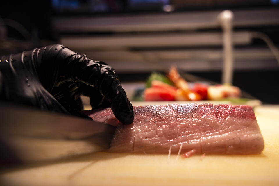 A chef prepares imported Japanese fish at a sashimi restaurant in Hong Kong, Friday, July 14, 2023. As Tokyo plans to discharge treated radioactive wastewater into the sea, Hong Kong’s Japanese restaurants and seafood suppliers are bracing for a slump in business under a potential ban by Hong Kong on aquatic products from 10 Japanese regions. (AP Photo/Louise Delmotte)