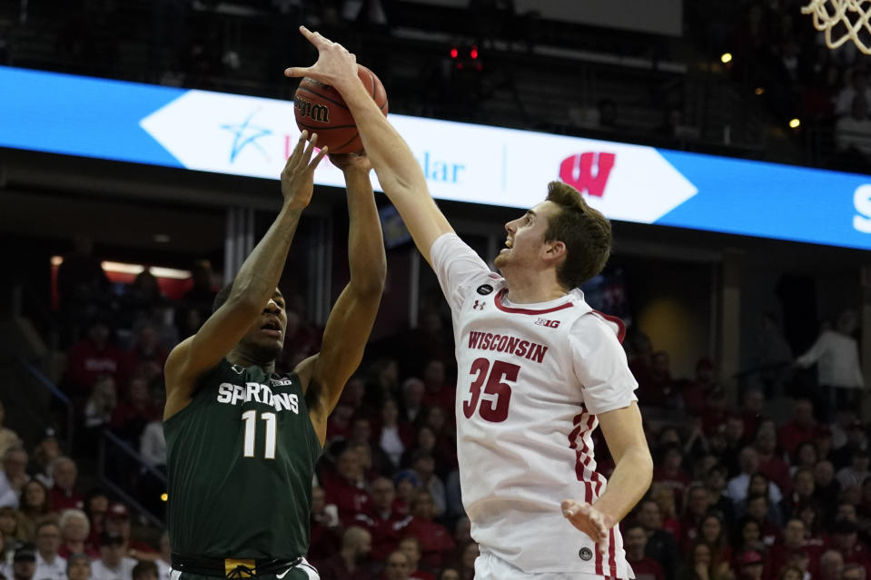 Wisconsin's Nate Reuvers (35) blocks a shot by Michigan State's Aaron Henry (11) during the first half of an NCAA college basketball game Saturday, Feb. 1, 2020, in Madison, Wis. (AP Photo/Andy Manis)