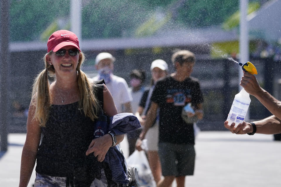 Fans gets spay with water after events were postponed due to high heat at the U.S. Olympic Track and Field Trials Sunday, June 27, 2021, in Eugene, Ore. (AP Photo/Ashley Landis)