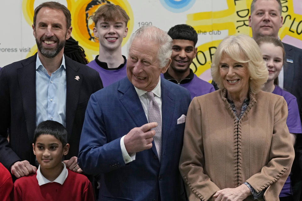 Britain's King Charles III, center, Camilla, the Queen Consort, right, and Gareth Southgate, England football manager and Prince's Trust ambassador, left, pose for a photograph with young people, staff and volunteers from the youth centre during a visit to the Norbrook Community Centre, Wythenshawe, in Manchester, England, Friday Jan. 20, 2023. (AP Photo/Frank Augstein, Pool)