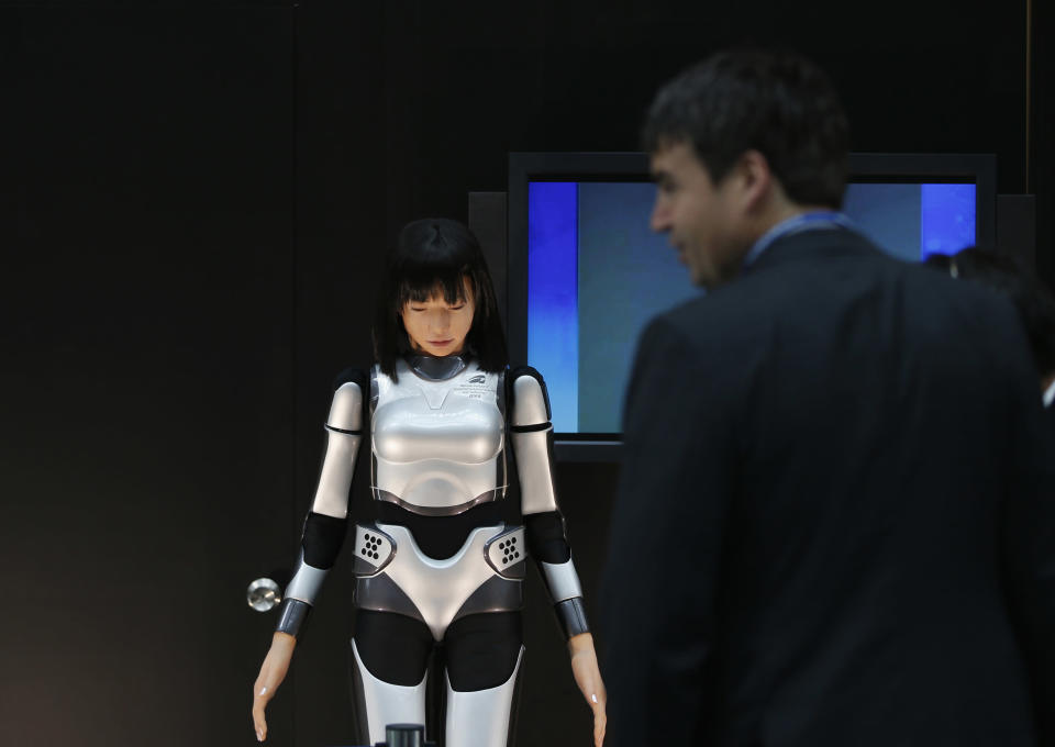 A man looks at the HRP-4C Miim humanoid robot at the venue of the Annual Meetings of the International Monetary Fund and the World Bank Group in Tokyo October 9, 2012. Global growth in advanced economies is too weak to bring down unemployment and what little momentum exists is coming primarily from central banks, the International Monetary Fund said in its World Economic Outlook, released ahead of its twice-yearly meeting, which will be held in Tokyo later this week. REUTERS/Toru Hanai (JAPAN - Tags: POLITICS BUSINESS)