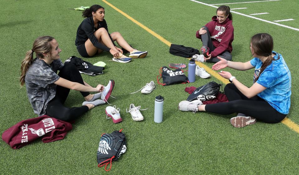 South Kitsap relay team members: (left to right) Elise Hopper, Marissa Crane, Ella Hopper and Savannah Kambich chat on the field as they take off their spikes to get ready to hit the weight room during practice in Port Orchard on Tuesday, May 10, 2022. 