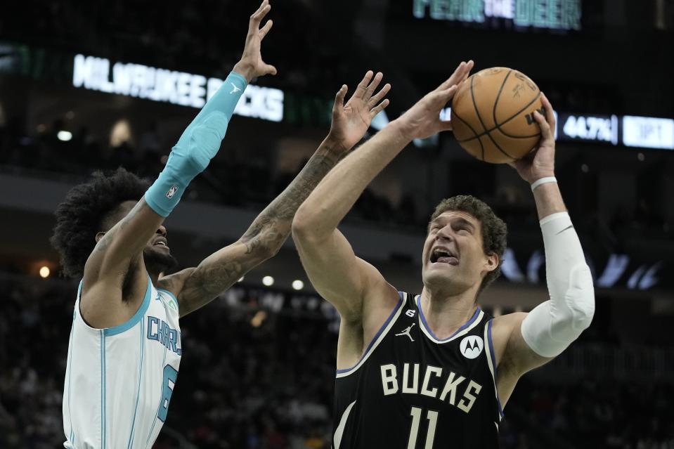 Milwaukee Bucks' Brook Lopez tries to shoot past Charlotte Hornets' Jalen McDaniels during the second half of an NBA basketball game Tuesday, Jan. 31, 2023, in Milwaukee. The Bucks won 124-115. (AP Photo/Morry Gash)