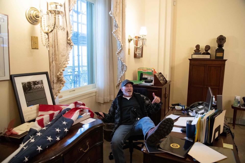 In this file photo taken on January 06, 2021 Richard Barnett, a supporter of U.S. President Donald Trump sits inside the office of House Speaker Nancy Pelosi, D-Calif., as he protested inside the Capitol in Washington, D.C. Prosecutors proposed an 87-month term for Barnett when he is sentenced May 24, 2023.