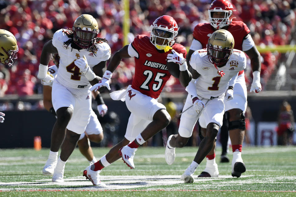 Louisville running back Jawhar Jordan (25) is pursued by Boston College defensive end Neto Okpala (4) and defensive back Elijah Jones (1) during the first half of an NCAA college football game in Louisville, Ky., Saturday, Sept. 23, 2023. (AP Photo/Timothy D. Easley)