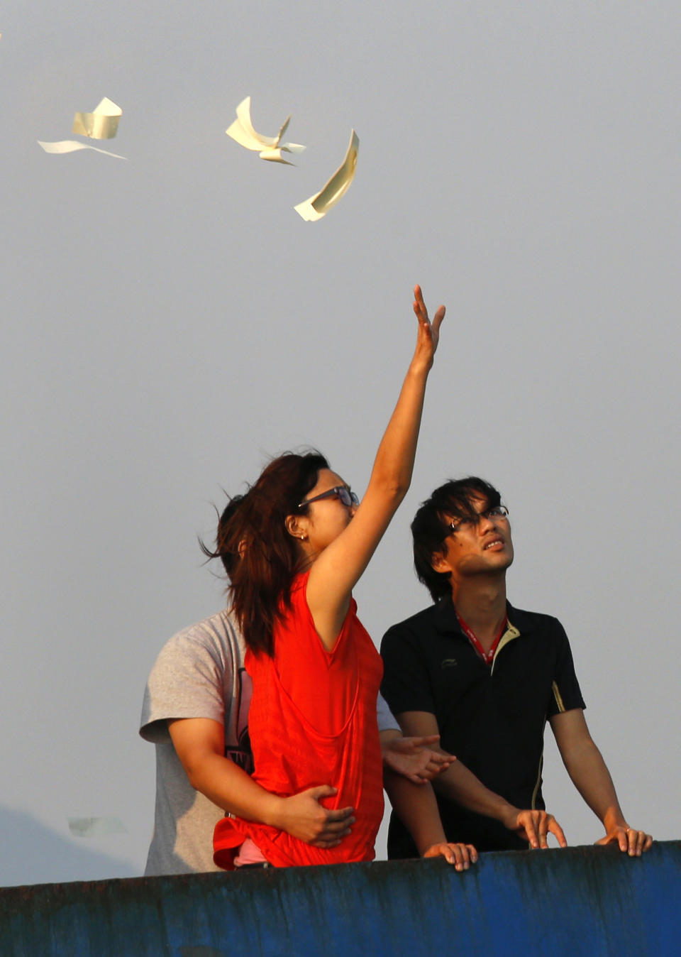 Relatives of the victims throw paper money Tuesday, Oct. 2, 2012 as they pay tribute to the ill-fated people aboard a boat that sank Monday night near Lamma Island, off the southwestern coast of Hong Kong Island. The boat packed with revelers on a long holiday weekend collided with a ferry and sank off Hong Kong, killing at least 36 people and injuring dozens, authorities said. (AP Photo/Vincent Yu)