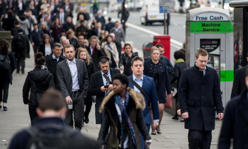 Commuters walk over London Bridge