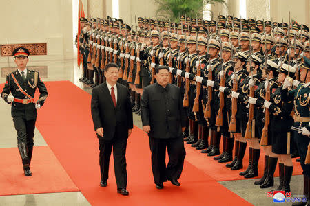 North Korean leader Kim Jong Un and Chinese President Xi Jinping inspect honor guards, as he paid an unofficial visit to Beijing, China, in this undated photo released by North Korea's Korean Central News Agency (KCNA) in Pyongyang March 28, 2018. KCNA/via Reuters