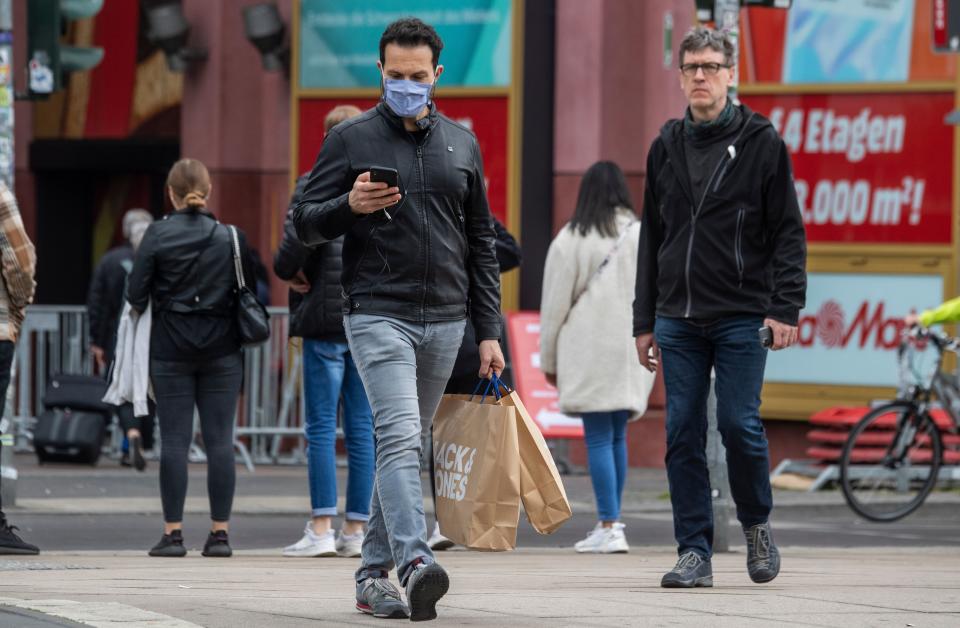 A man wearing a face mask walks out of a shopping mall in Berlin on April 29, 2020 amid the new coronavirus COVID-19 pandemic. - Face masks have been made mandatory in shops all over Germany. (Photo by John MACDOUGALL / AFP) (Photo by JOHN MACDOUGALL/AFP via Getty Images)