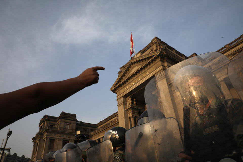 Police form a cordon in front of the Justice Palace as people who are refusing to recognize the new government arrive, in Lima, Peru, Wednesday, Nov. 11, 2020. On Tuesday, Peru swore in Manuel Merino as president, after Peru’s legislature booted President Martin Vizcarra from office on Monday. (AP Photo/Rodrigo Abd)