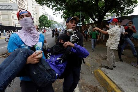 Un manifestante herido es ayudado durante enfrentamientos con fuerzas de seguridad mientras protestan contra el Gobierno del presidente venezolano Nicolás Maduro en Caracas, Venezuela, 20 de abril de 2017. REUTERS/Marco Bello - RTS13878