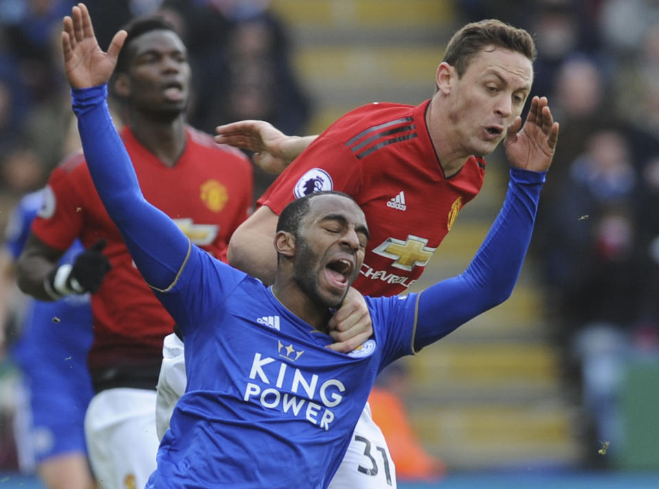 Leicester's Ricardo Pereira, left, falls as he challenge for the ball with Manchester United's Nemanja Matic during the English Premier League soccer match between Leicester City and Manchester United at the King Power Stadium in Leicester, England, Sunday, Feb 3, 2019. (AP Photo/Rui Vieira)