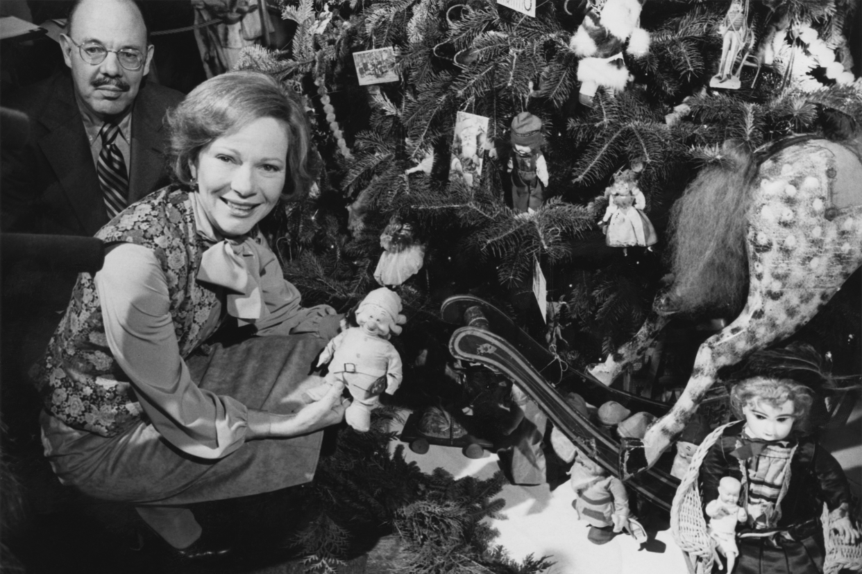 First Lady of the United States Rosalynn Carter holding a doll under the Christmas tree