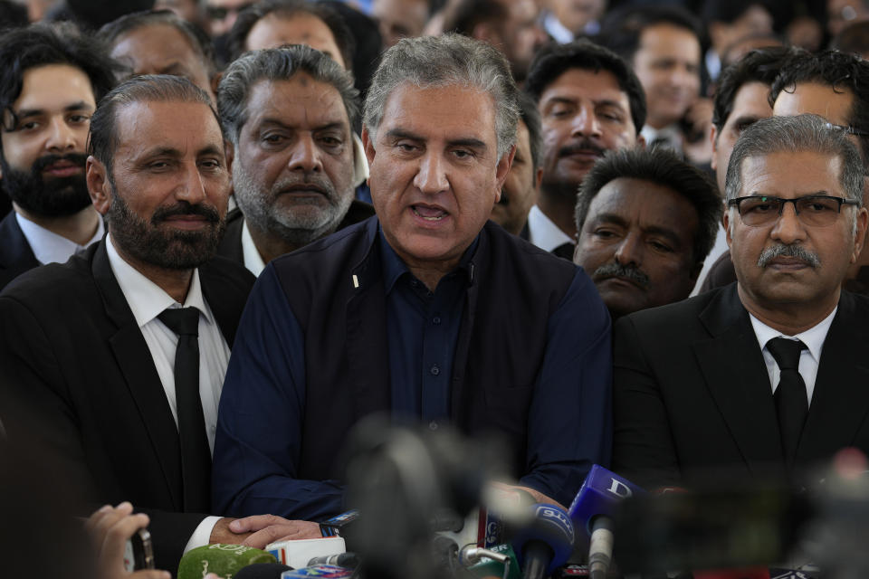 Shah Mahmood Qureshi, center, a leader of former premier Imran Khan's Tahreek-e-Insaf party, is surrounded by party leaders and workers as he speaks outside the Supreme Court following court decision regarding provincial elections, in Islamabad, Pakistan, Tuesday, April 4, 2023. Pakistan's Supreme Court ruled a panel's decision to delay provincial elections was unconstitutional and ordered the votes held by May 14, according to a lawyer involved in the case. (AP Photo/Anjum Naveed)