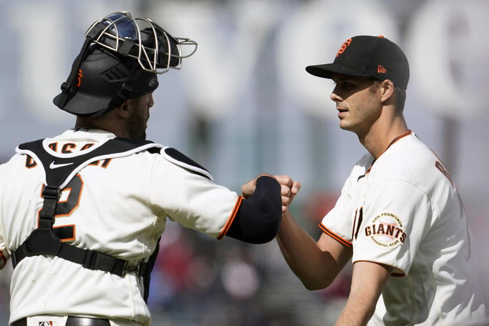 San Francisco Giants catcher Curt Casali, left, celebrates with pitcher Tyler Rogers after the Giants defeated the Miami Marlins in a baseball game in San Francisco, Sunday, April 25, 2021. (AP Photo/Jeff Chiu)