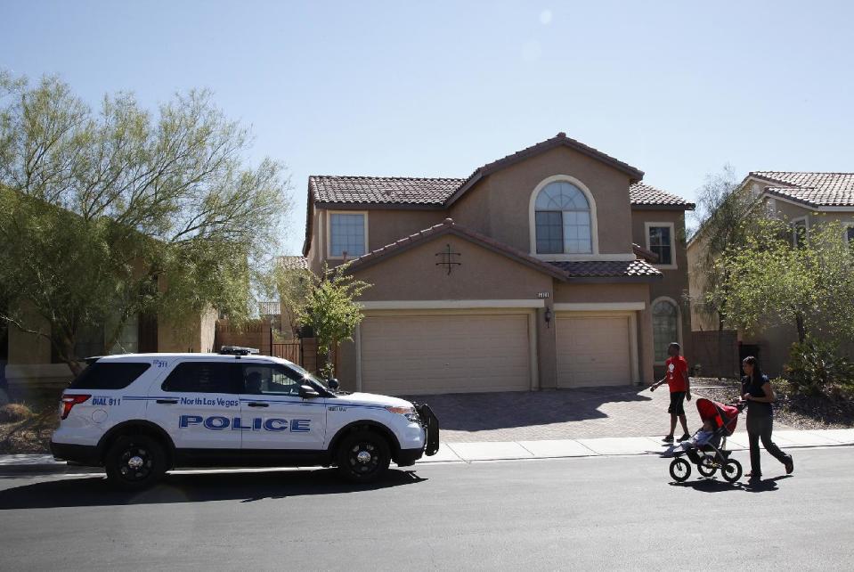 Sheldon Jacobs and his wife Nicole Jacobs walk in front of a home on the 6100 block of Stibor Street in North Las Vegas on Tuesday, April 1, 2014. Police in North Las Vegas think a family member may be responsible for a double-slaying at this home where officers sent to check on a missing 53-year-old mother and her 33-year-old daughter found a bloody crime scene. (AP Photo/Las Vegas Review-Journal, Justin Yurkanin) LOCAL TV OUT; LOCAL INTERNET OUT; LAS VEGAS SUN OUT