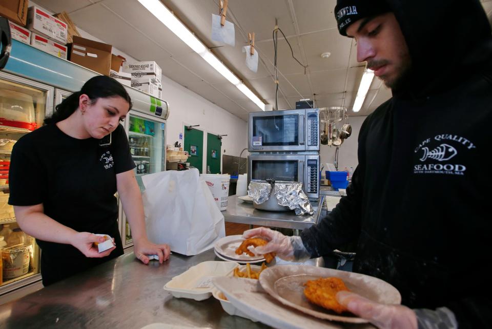 Tabitha Shelford, takes a phone order, as Jacob Goncalo prepares a takeout order at Cape Quality Seafood on Dartmouth Street in Dartmouth.