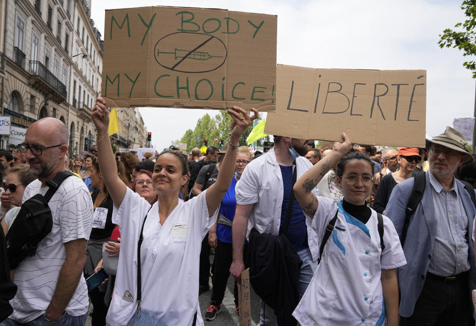 Nurses hold placards as they march during an anti-vaccine protest in Paris, Saturday, July 17, 2021. Tens of thousands of people protested across France on Saturday against the government's latest measures to curb rising COVID-19 infections and drive up vaccinations in the country. (AP Photo/Michel Euler)