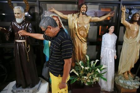 A man touches a religious statue after a service in a chapel at Camp Crame, the headquarters of Philippine National Police (PNP) in Manila, Philippines October 9, 2016. REUTERS/Damir Sagolj