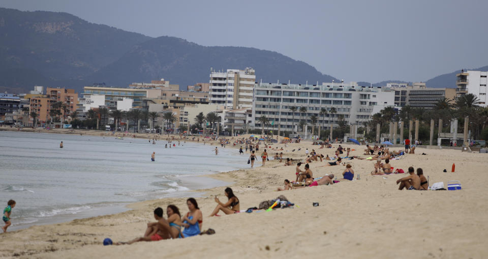 25 May 2020, Spain, Palma de Mallorca: People sunbathe on the beach of Arenal. After more than two months of forced closure due to the Corona pandemic, the holiday island and many other regions of Spain reopened their beaches on Monday. Photo: Clara Margais/dpa (Photo by Clara Margais/picture alliance via Getty Images)