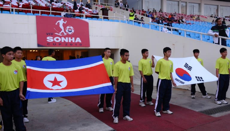 Flags of North Korea (L) and South Korea are carried prior to a football match between the two countries' U-23 teams during the Vietnam Football (VFF) Federation Son Ha Cup tournament on November 4, 2010