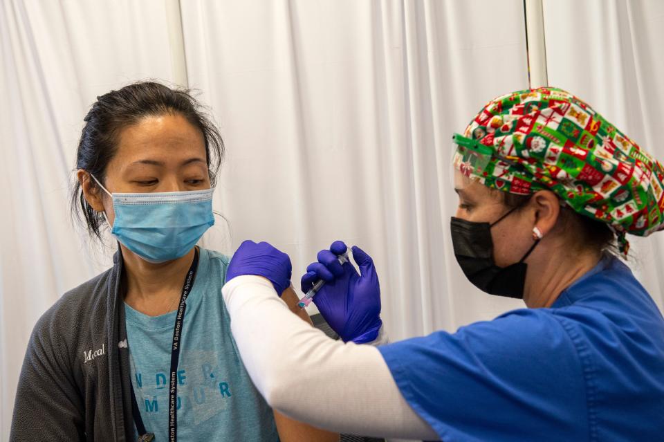 Nurse and Army Veteran Renee Langone administers a Moderna Covid-19 vaccine to US Air Force (active duty reservist) Doctor Pei-Chun McGregor at the West Roxbury VA Medical Center in Boston, Massachusetts on December 23, 2020. - The VA is vaccinating front line workers and at risk patients during phase one. More than a million people have received their first dose of a Covid-19 vaccine in the United States, Centers for Disease Control and Prevention (CDC) director Robert Redfield said December 23. (Photo by Joseph Prezioso / AFP) (Photo by JOSEPH PREZIOSO/AFP via Getty Images)