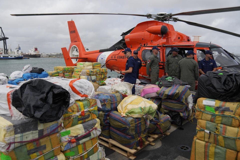 Members of the U.S. Coast Guard stand alongside bundles of seized cocaine and marijuana worth more than one billion dollars, aboard Coast Guard Cutter James at Port Everglades, Thursday, Feb. 17, 2022, in Fort Lauderdale, Fla. The Coast Guard said the haul included approximately 54,500 pounds of cocaine and 15,800 pounds of marijuana from multiple interdictions in the Caribbean Sea and the eastern Pacific. (AP Photo/Rebecca Blackwell)