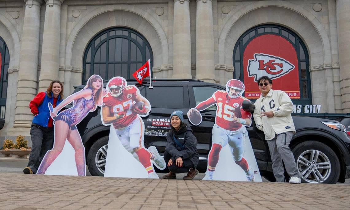 Journalists Alison Booth, left, Emily Curiel and Irvin Zhang pose for a photo in front of Union Station next to cutouts featuring pop star Taylor Swift, Kansas City Chiefs tight end Travis Kelce and Kansas City Chiefs quarterback Patrick Mahomes in Kansas City.