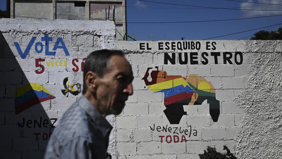 A man walks by a mural campaigning for the referendum on November 28, 2023. - Federico Parra/AFP/Getty Images