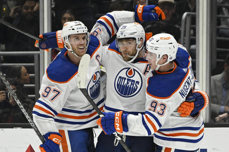 Edmonton Oilers center Leon Draisaitl, center, celebrates his goal with center Connor McDavid, left, and center Ryan Nugent-Hopkins during the second period of an NHL hockey game Tuesday, April 4, 2023, in Los Angeles. (AP Photo/Mark J. Terrill)