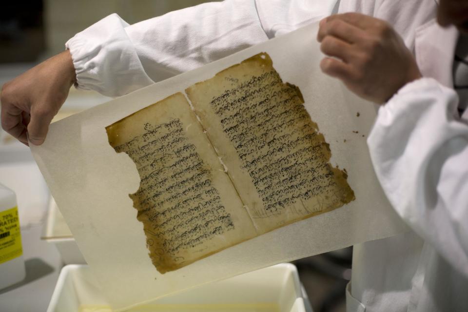 In this photo taken on Monday, Jan. 27, 2014, an employee works on a restoration of an old manuscript at the al-Aqsa mosque compound library in Jerusalem. The library has a collection of some 4,000 old manuscripts with about a quarter considered in poor condition. Half of the books are already undergoing restoration funded by the Waqf, Jordan’s Islamic authority which manages the holy site, and with assistance from UNESCO. (AP Photo/Dusan Vranic)