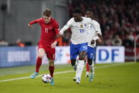 Denmark's Andreas Skov Olsen, left, and France's Benoit Badiashile in action during the UEFA Nations League soccer match between Denmark and France at Parken Stadium in Copenhagen, Denmark, Sunday Sept. 25, 2022. (Liselotte Sabroe/Ritzau Scanpix via AP)