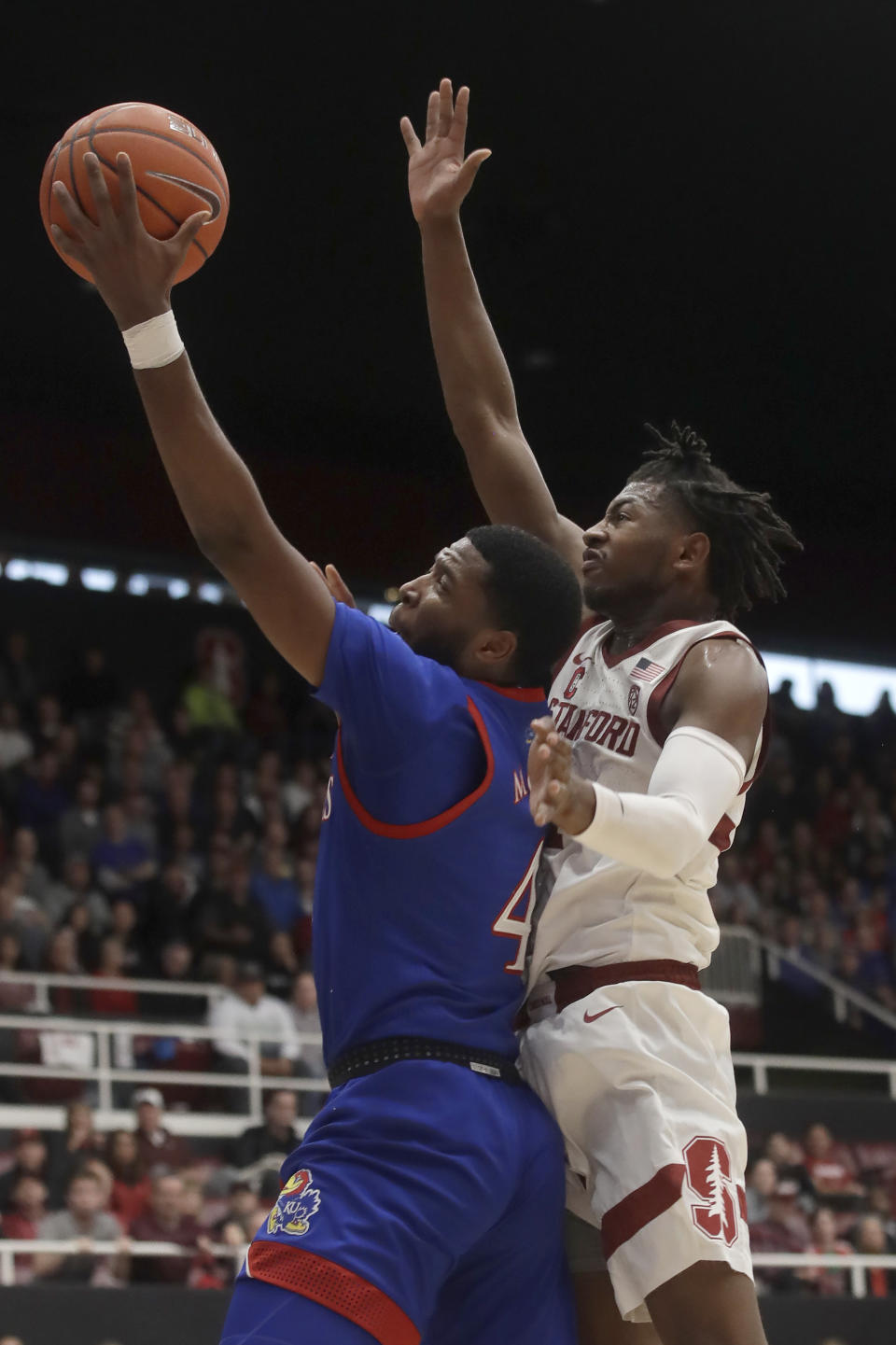 Kansas guard Isaiah Moss, left, shoots against Stanford guard Daejon Davis during the first half of an NCAA college basketball game in Stanford, Calif., Sunday, Dec. 29, 2019. (AP Photo/Jeff Chiu)