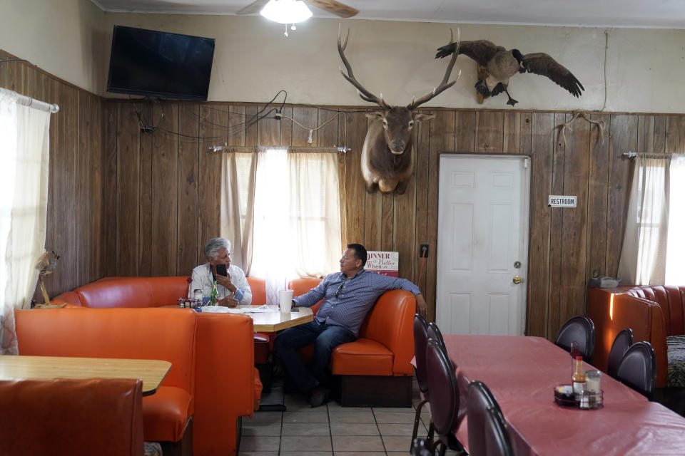 Luis Olmedo, right, executive director of Comite Civico Del Valle, talks to fellow activist John Hernandez inside the Buckshot Restaurant in Niland, Calif., Thursday, July 15, 2021. Demand for electric vehicles has shifted investments into high gear to extract lithium from geothermal wastewater around the nearby Salton Sea. “How do we end up with this great opportunity before us but at the same time not get burned?” said Olmedo. (AP Photo/Marcio Jose Sanchez)