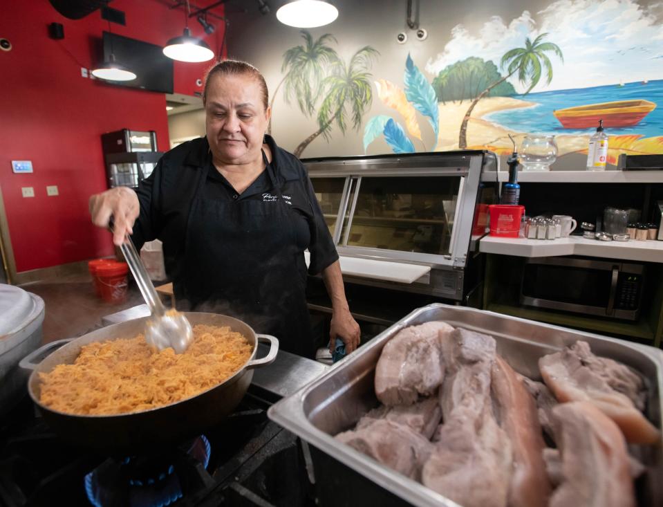 Mirqueya Tejeda prepares chicken for empanadas Wednesday at the Delicias Latin Food and Bar restaurant on Nine Mile Road in Pensacola.