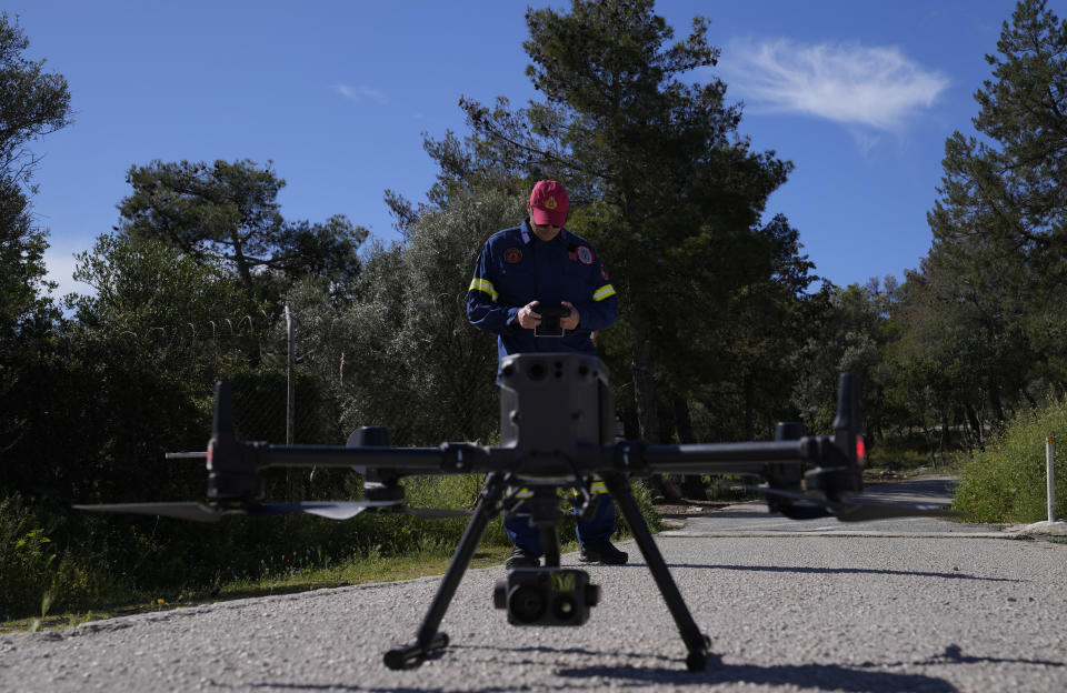 A firefighter checks the control of a drone during a preparedness drill at Glyka Nera, in northeastern Athens on Thursday, April 4, 2024. Authorities have stepped up exercises ahead of the official start of the fire season on May 1. (AP Photo/Thanassis Stavrakis)