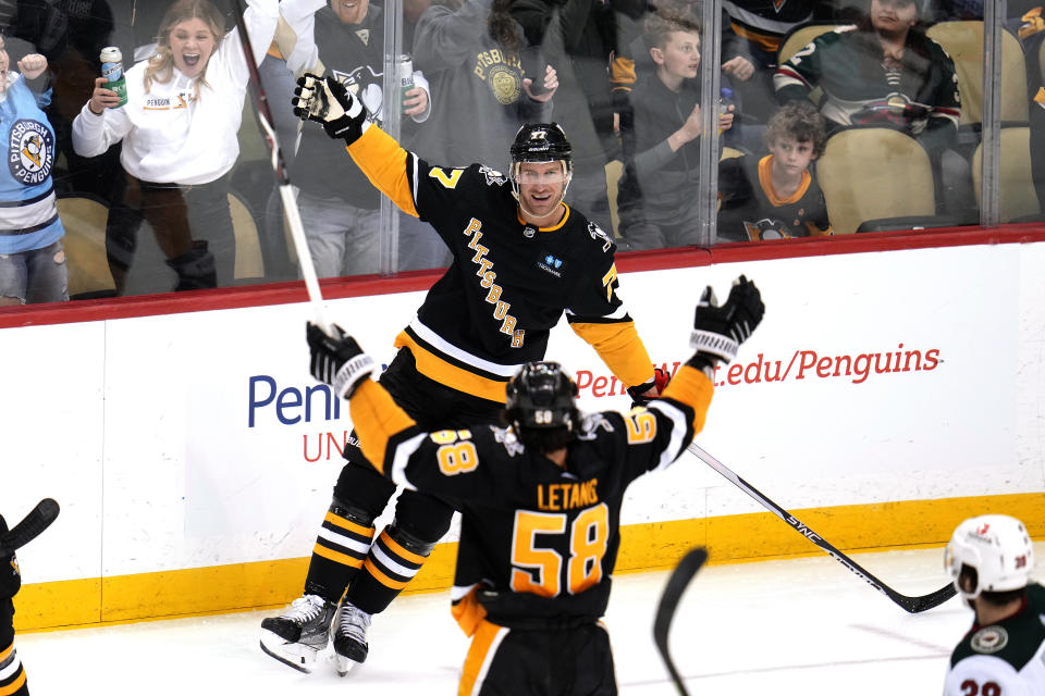 Pittsburgh Penguins' Jeff Carter (77) celebrates after his goal with Kris Letang (58) during the third period of an NHL hockey game against the Minnesota Wild in Pittsburgh, Thursday, April 6, 2023. (AP Photo/Gene J. Puskar)