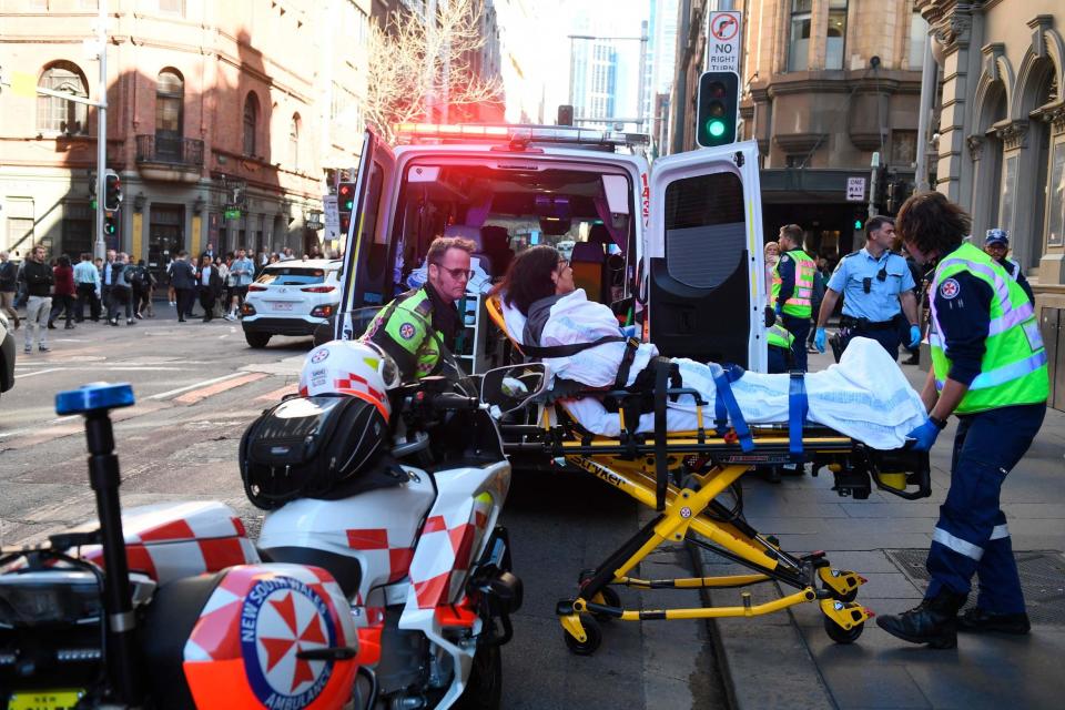 A woman is taken by ambulance to hospital after the stabbing (AP)