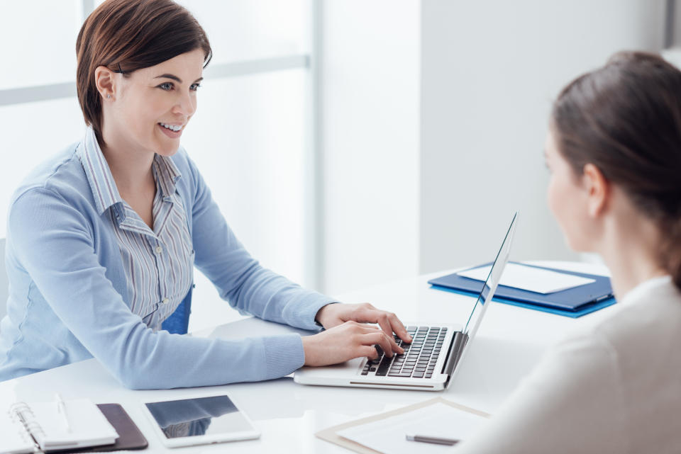 A human resources employee assists another employee in her office.