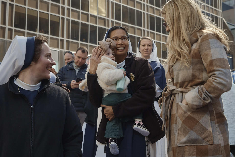 A nun holds a baby as participants march along Fifth Avenue during the St. Patrick's Day Parade on Saturday, March 16, 2024, in New York. (AP Photo/Andres Kudacki)