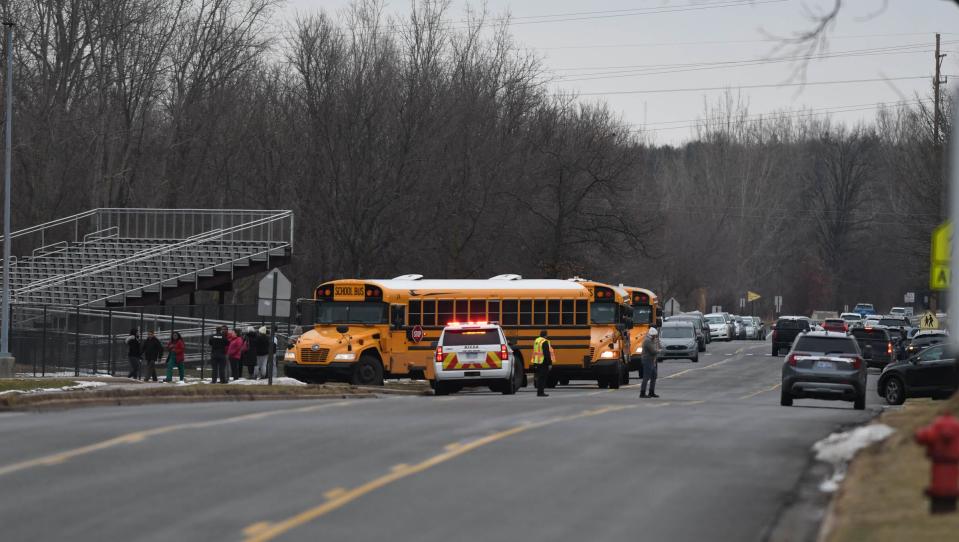 Buses staged outside the football field at Okemos High School, Tuesday, Feb. 7, 2023, to transport students away from the school to meet their parents.