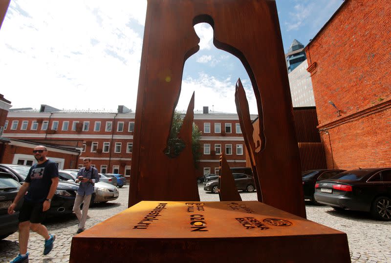 People walk past a monument honouring delivery couriers who continued to work throughout the outbreak of the coronavirus disease (COVID-19), in Moscow