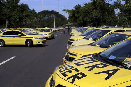 Taxis parked on the street, one with words which reads "Out Uber", are pictured during a protest against the online car-sharing service Uber in Rio de Janeiro, Brazil July 24, 2015. REUTERS/Ricardo Moraes