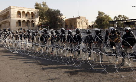 Riot policemen stand in front of protesters during demonstration against the poor quality of basic services, power outages and calling for trial of corrupt politicians in Baghdad, Iraq, September 4, 2015. REUTERS/Ahmed Saad