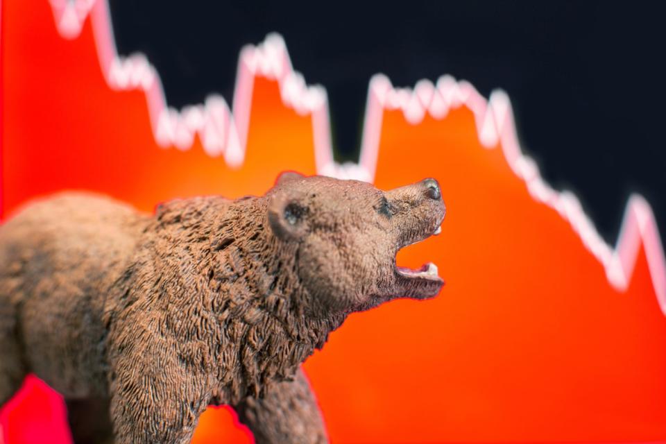 A snarling bear set in front of a plunging stock chart.