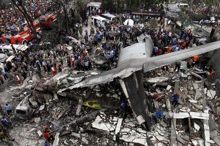 Security forces and rescue teams examine the wreckage of an Indonesian military C-130 Hercules transport plane after it crashed into a residential area in the North Sumatra city of Medan, Indonesia, June 30, 2015. REUTERS/Roni Bintang