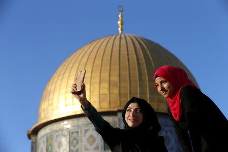 Salma Salame (L), 27, from the Arab-Israeli town of Baqa al-Gharbiyye, takes a selfie photo with a friend in front of the Dome of the Rock on the compound known to Muslims as Noble Sanctuary and to Jews as Temple Mount, in Jerusalem's Old City, during the holy month of Ramadan, July 4, 2015. REUTERS/Ammar Awad